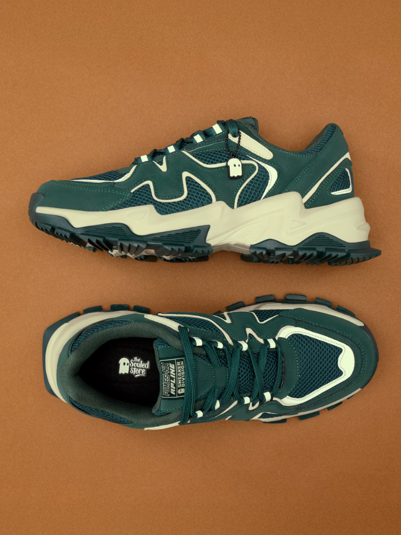 Teal green chunky sneakers with white accent panels and rugged rubber outsole — side and top view on brown background